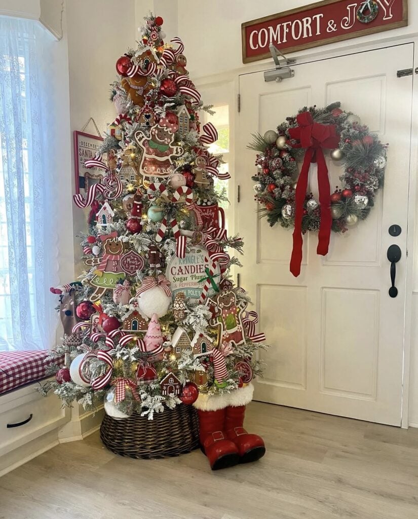 Entryway gingerbread Christmas tree with red and white candy cane decorations, cookie ornaments, and matching door garland.