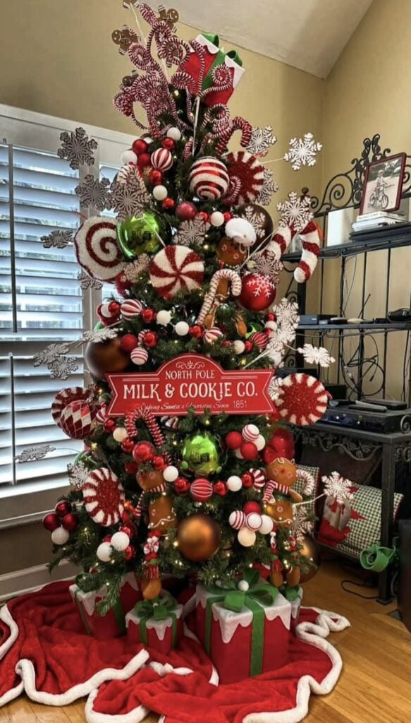 Red, white, and green milk-and-cookies themed gingerbread Christmas tree with cookie ornaments, candy canes, and playful text signs.