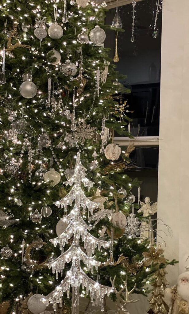 Crystal-icicle winter wonderland tree with glass ornaments, gold accents, and reindeer décor at the base.