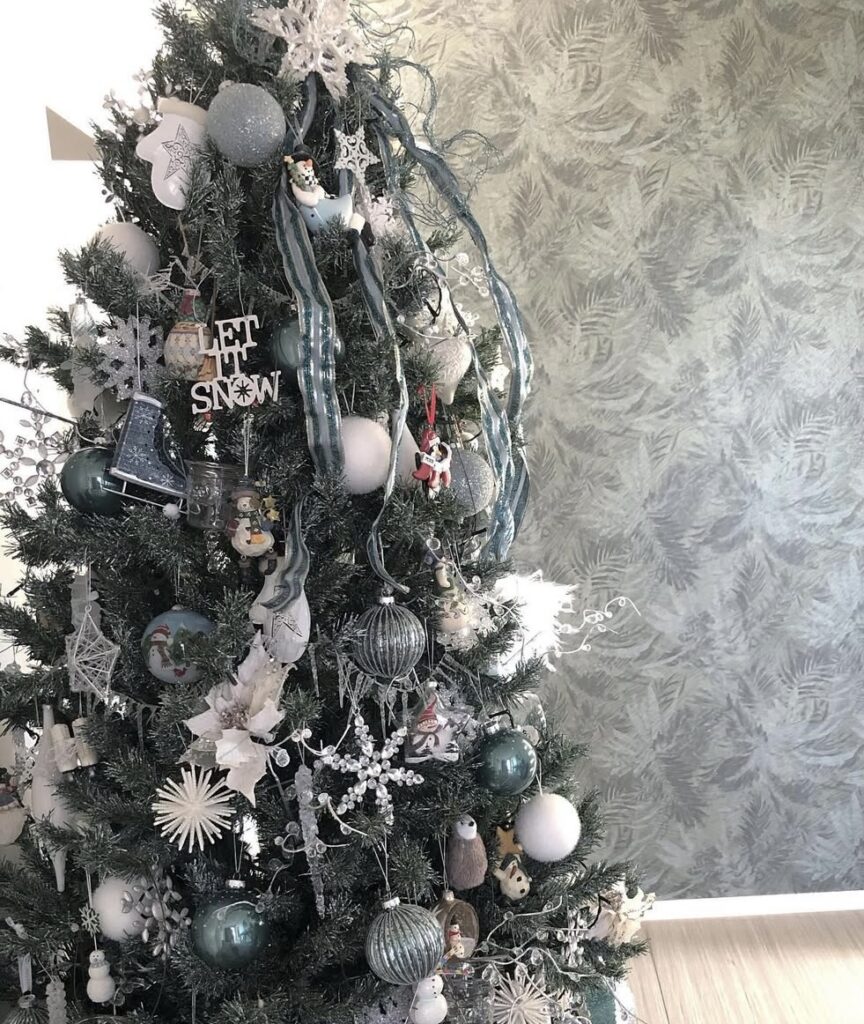 Blue-and-white winter wonderland Christmas tree with “Let it snow” accents, snowflakes, and a cheerful snowman.