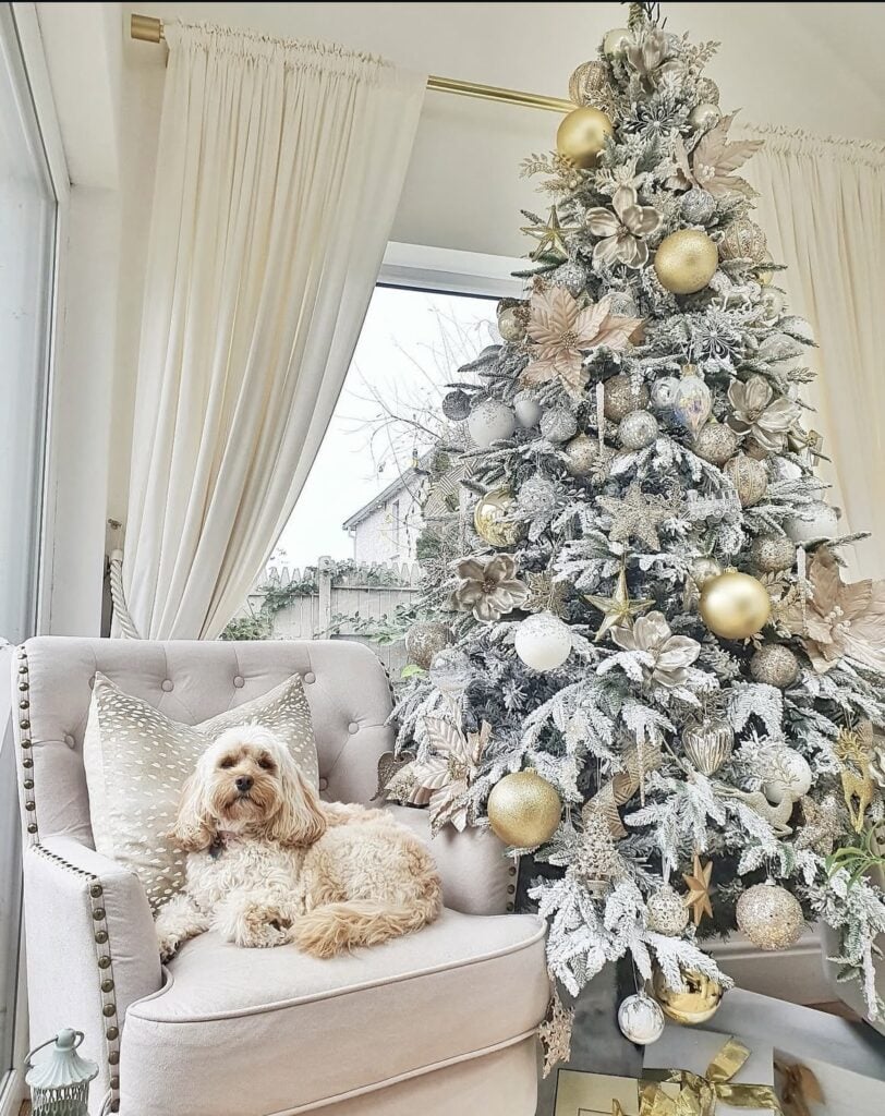 Champagne-and-gold winter wonderland tree with metallic ornaments, creamy ribbon, and a cute pup by the base.