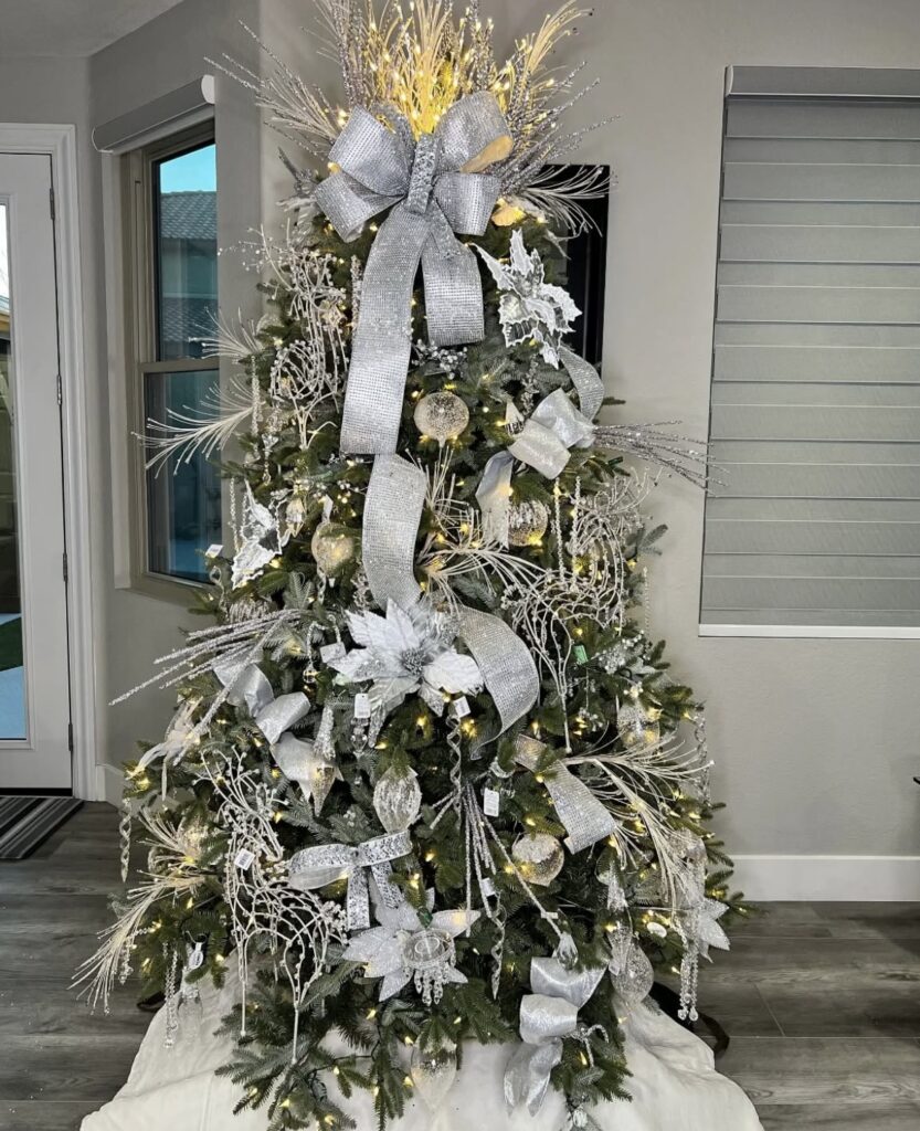 Winter wonderland Christmas tree with crystal sprays and oversized silver bow topper.