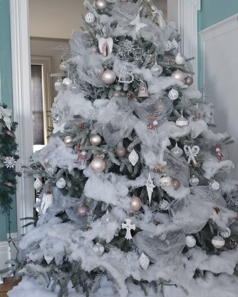 Snow-cloud winter wonderland tree with blush pink ornaments, frosted branches, and dreamy warm lights.