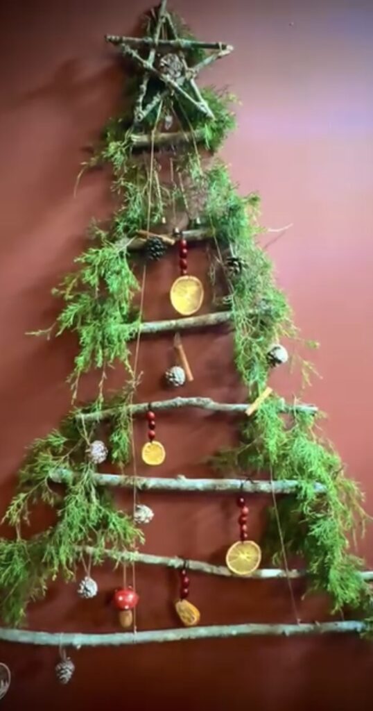 Natural alternative Christmas tree idea using greenery and festive holiday accents