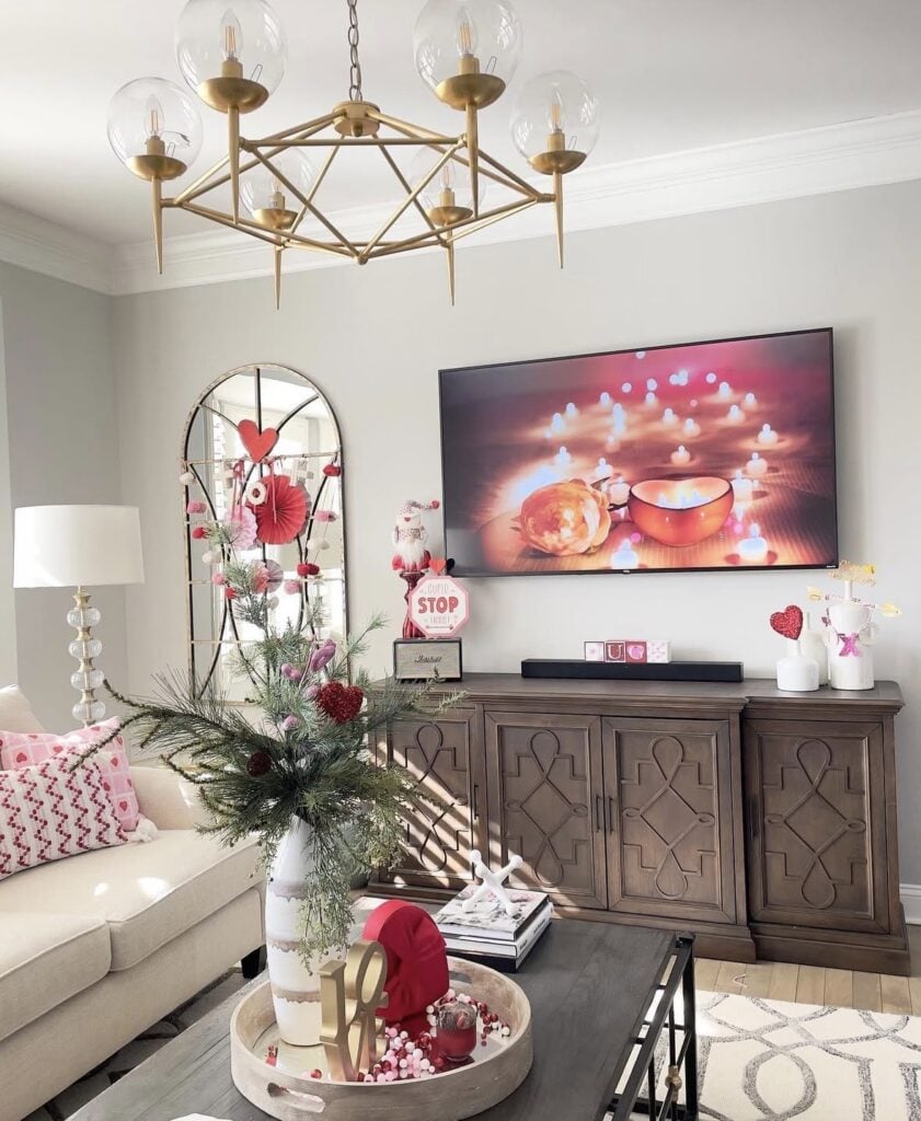Romantic red Valentine’s Day tablescape with candles, layered place settings, and classic heart-themed decor.