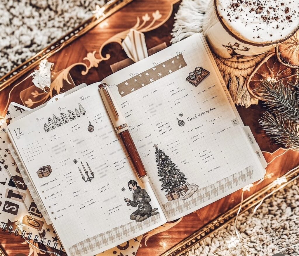 Festive weekly planner spread with gold Christmas colors, stickers, and decorative accents.