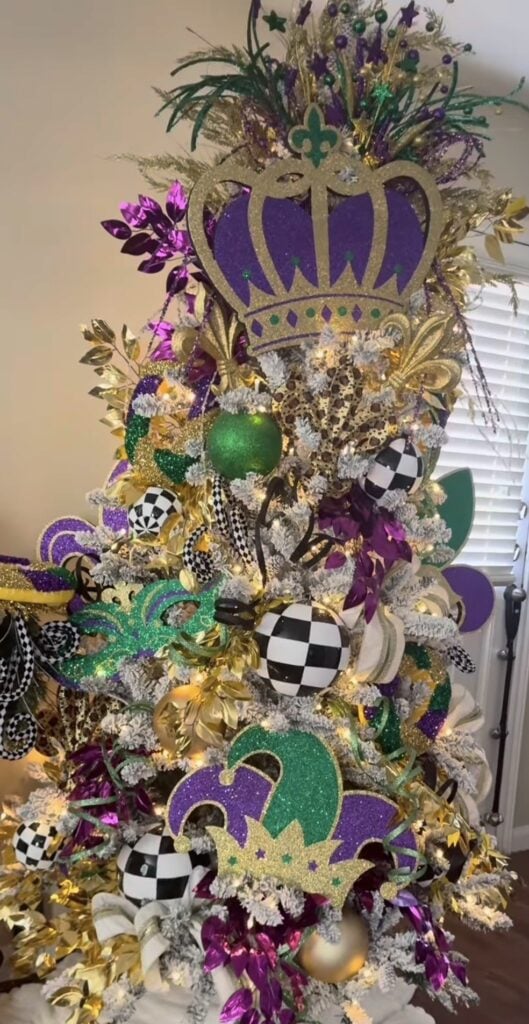 Mardi Gras Christmas tree with layered ribbon, bold bow styling, and clustered purple, green, and gold ornaments for a parade-ready look.