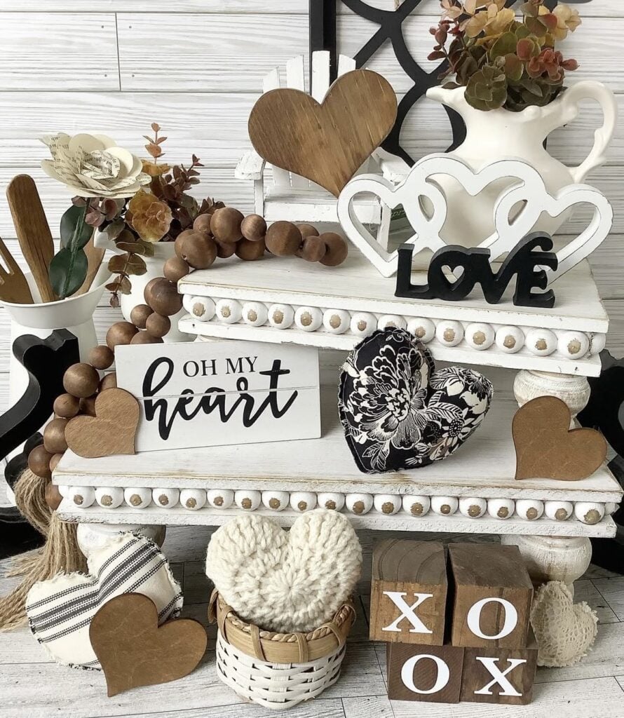 Neutral valentines day tiered tray with neutral styling with white square two tier tray, brown, natural hearts, love sign and xoxo blocks