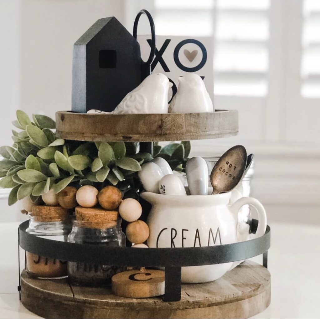 Tiered tray with XO sign, white ceramic birds, cream crock, greenery, and wood beads in neutral Valentine styling.