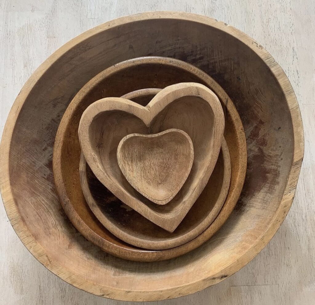 Rustic wooden nested heart bowls arranged in a neutral flat lay for Valentine’s Day decor.