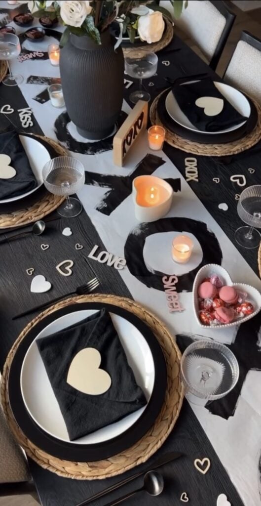 valentines tablescape using black white and tan with xoxo table runner, black napkins and cream hearts