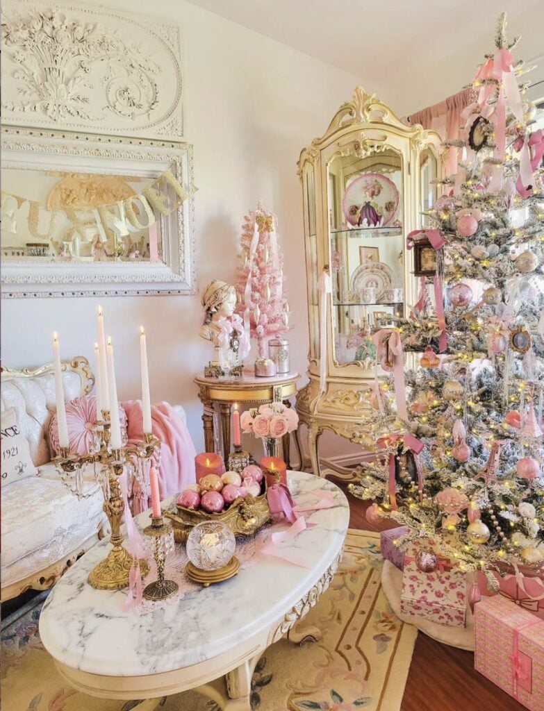 Romantic pink and gold Christmas tree decorated with blush ornaments and ribbons in an ornate vintage-style living room.