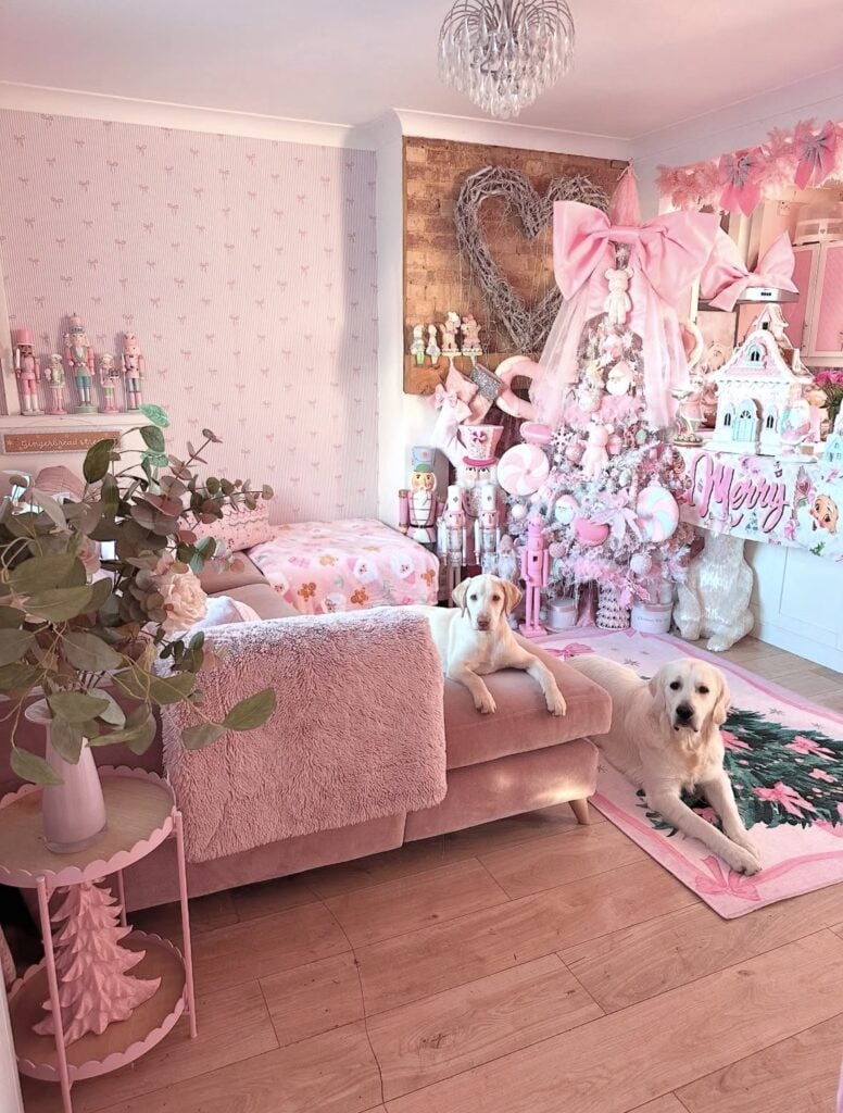 Whimsical pink Christmas room with a flocked tree covered in oversized candy decorations, pastel ornaments, and a giant pink bow.