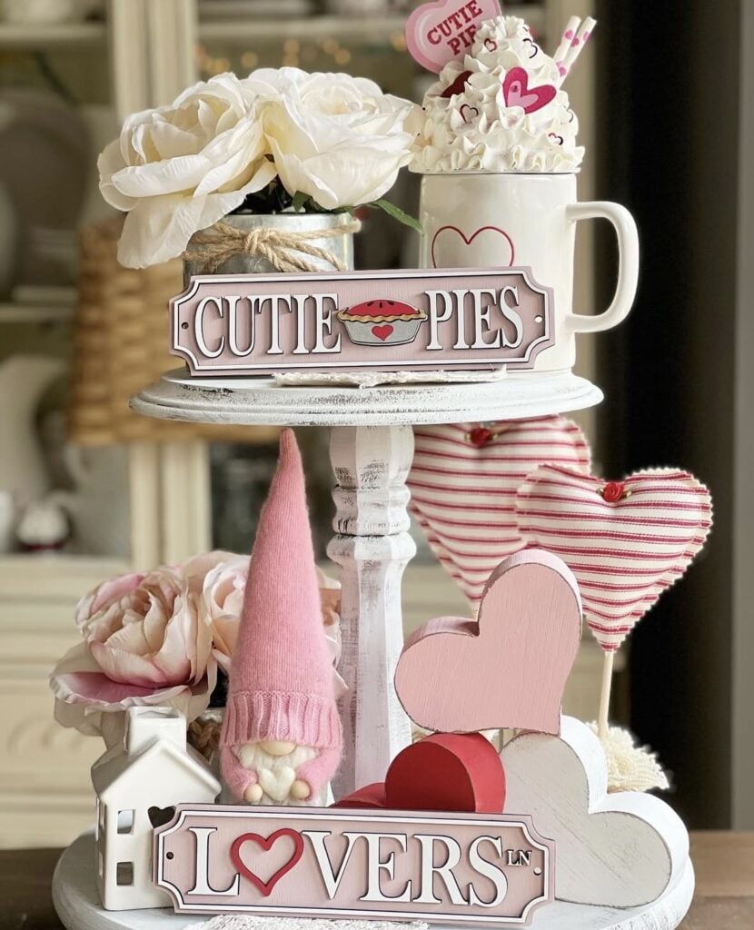 Romantic farmhouse Valentine tiered tray decor with gnome accents, heart garland, a ‘Hello Valentine’ sign, and soft pink details