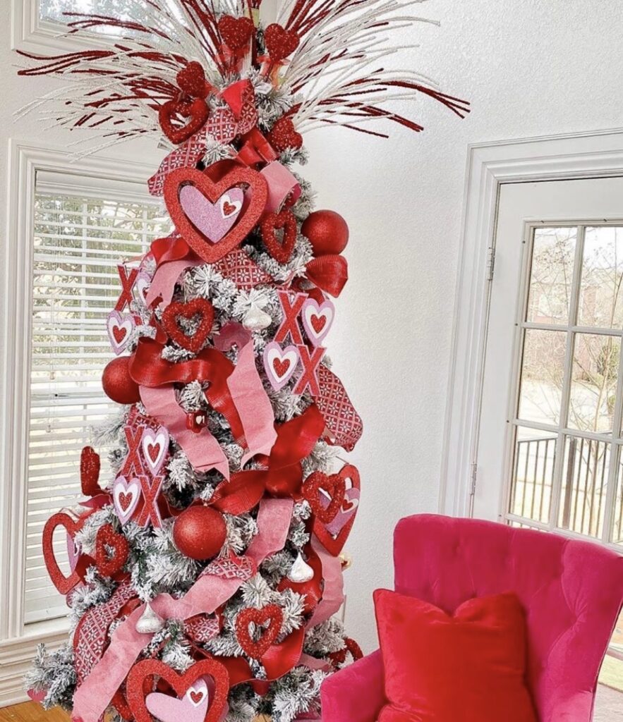 Valentines Day tree filled with layered heart ornaments, mesh ribbon, and twinkle lights, credit therealmlandreth59.