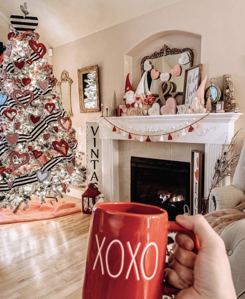 white christmas tree with black and white ribbon and red heart decorations and cozy lights credit decorsteals