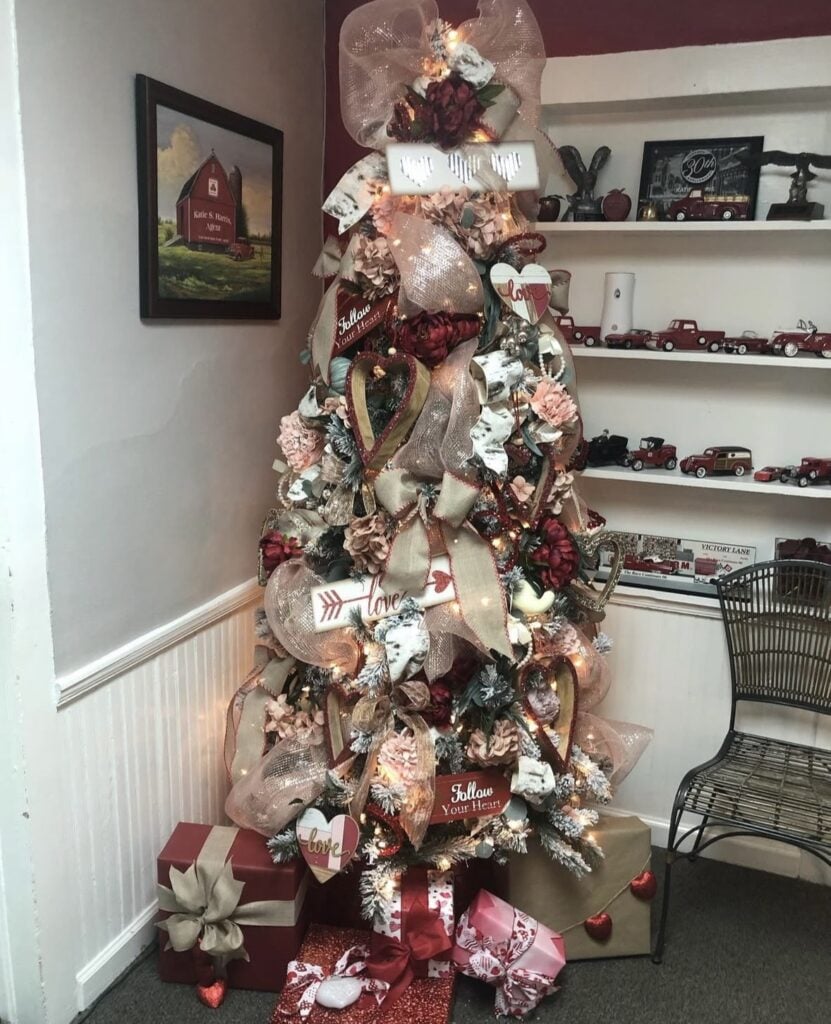 Valentines Day tree featuring bright red and pink hearts, ribbon, and custom balloon style decor, credit wrapstaratlanta.