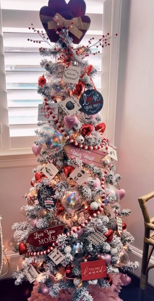 Rustic and skinny Valentines Day tree with weathered signs and romantic touches, including hearts and candy and ribbon, credit thecagedmuse.