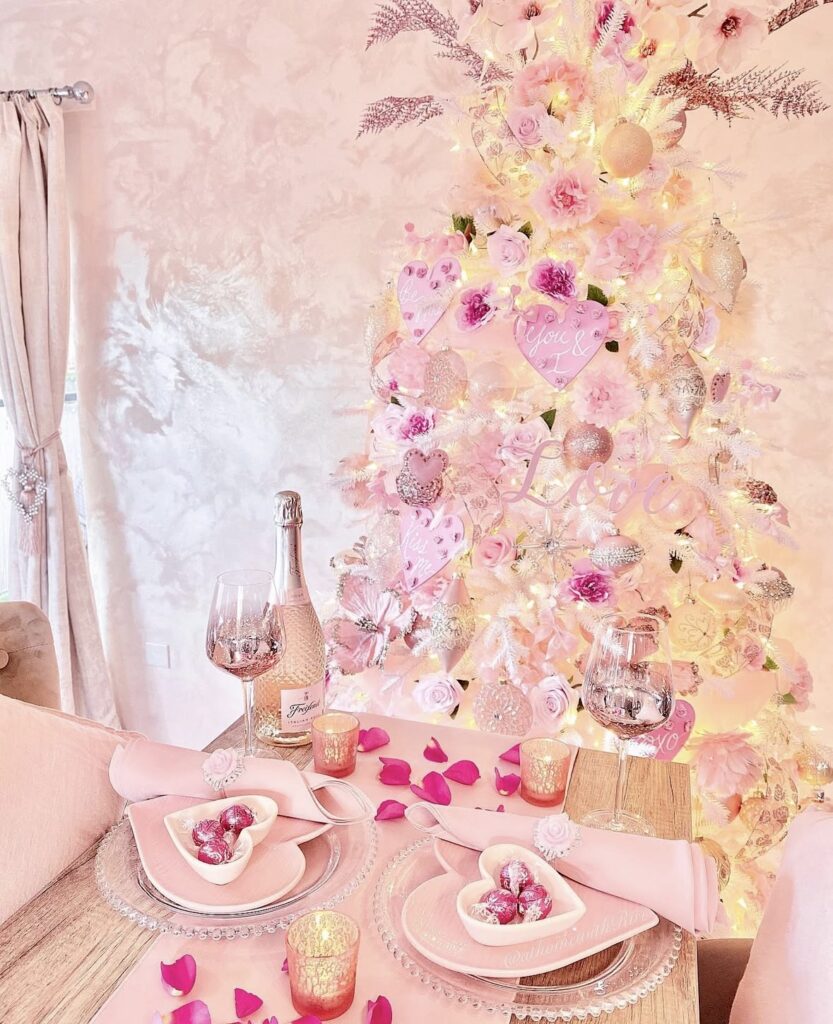 Pink Valentines Day tree with light pink and white ornaments, heart garland, and a simple tree skirt, credit athomewithriri.