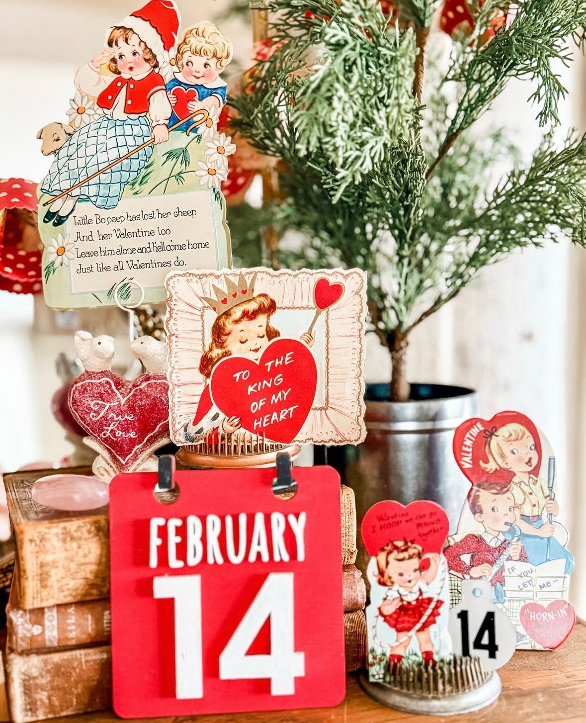 Vintage Valentine tabletop decor with a February 14 calendar, retro Valentine cards, and classic red heart details.