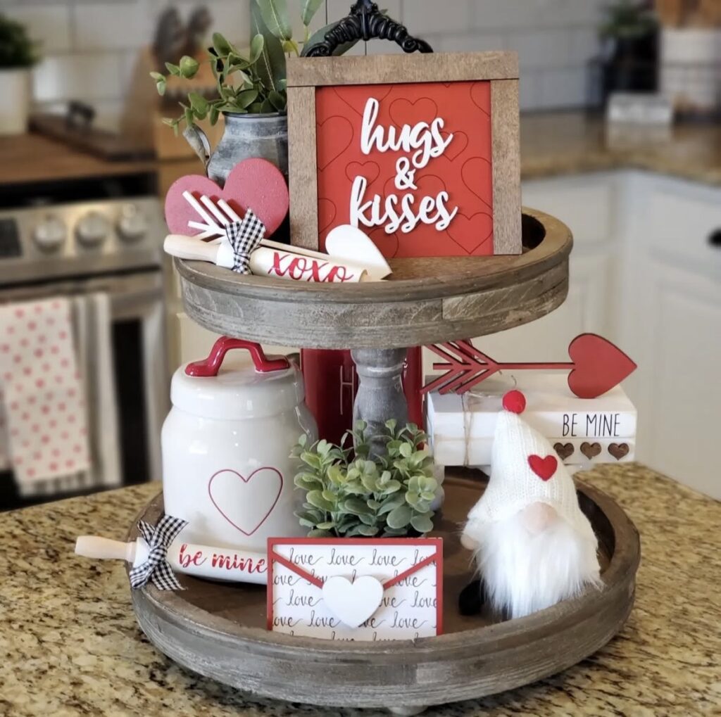 Red Valentine tiered tray styled with roses, heart signs, greenery, and cute candy touches.