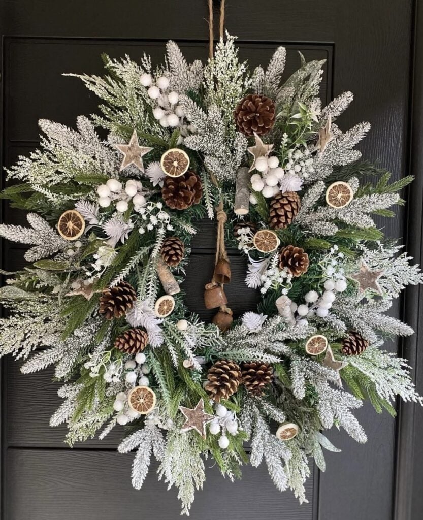 Handmade Winter Solstice wreath crafted with evergreen branches, pine cones, dried botanicals, and natural woodland elements.