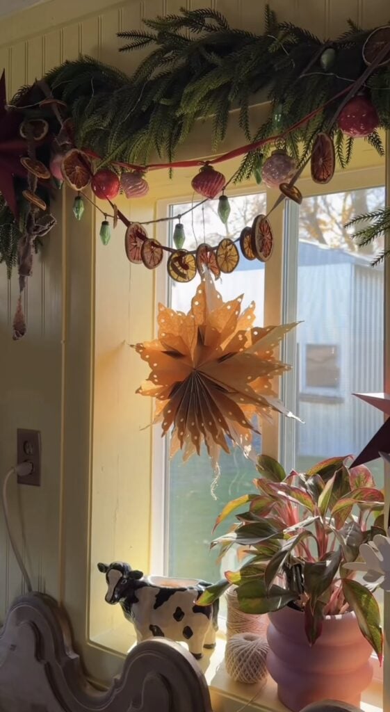 Winter Solstice decor featuring paper stars, candles, greenery, rustic wood accents, and warm natural textures for seasonal gatherings.