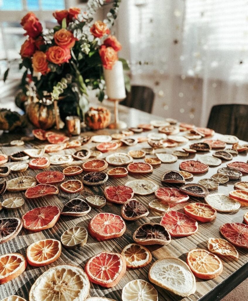 Rustic winter kitchen decorated with evergreen garlands, dried oranges, candles, and natural woodland accents for cozy Winter Solstice decor.