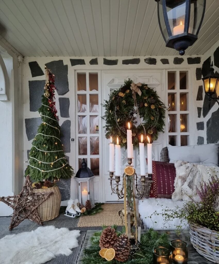 Cozy Winter Solstice tree on porch featuring dried orange slices, pinecones, greenery, and handcrafted natural ornaments in neutral tones.