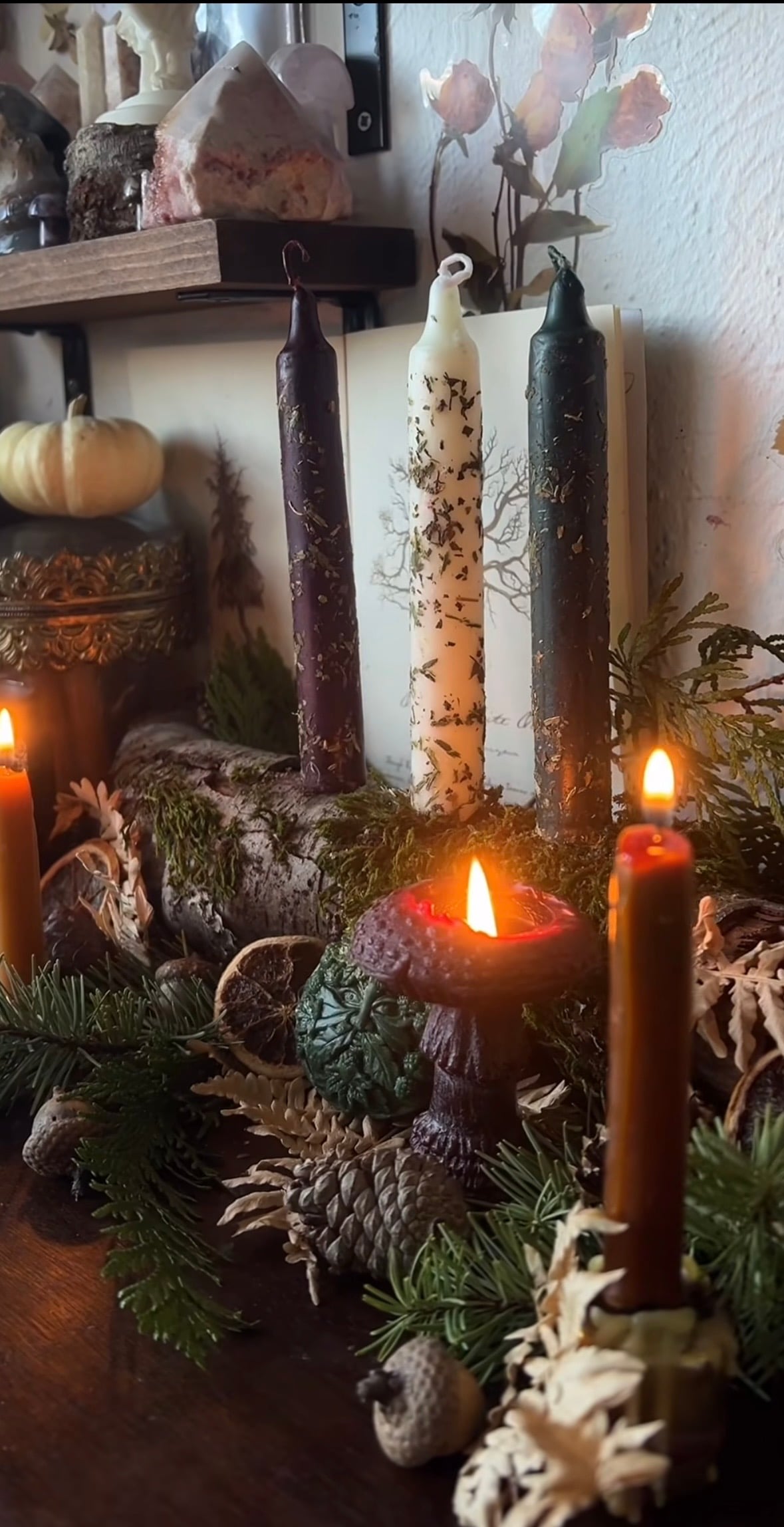 Handmade Yule wreath decorated with evergreen, dried oranges, pine cones, stars, and natural woodland accents.