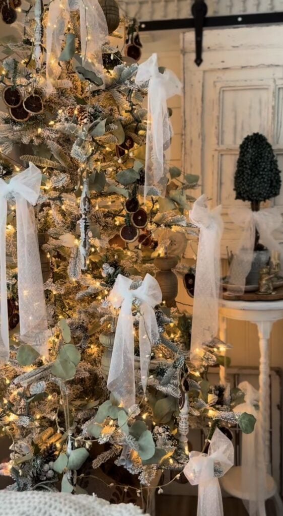 Woodland-inspired Winter Solstice tree with evergreen branches, candles, rustic ornaments, and natural decorations celebrating Yule traditions.