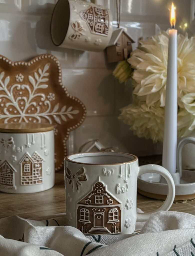 Cozy gingerbread Christmas coffee station with gingerbread house mugs, matching plate, and layered holiday decor, featured by slowestuff.com