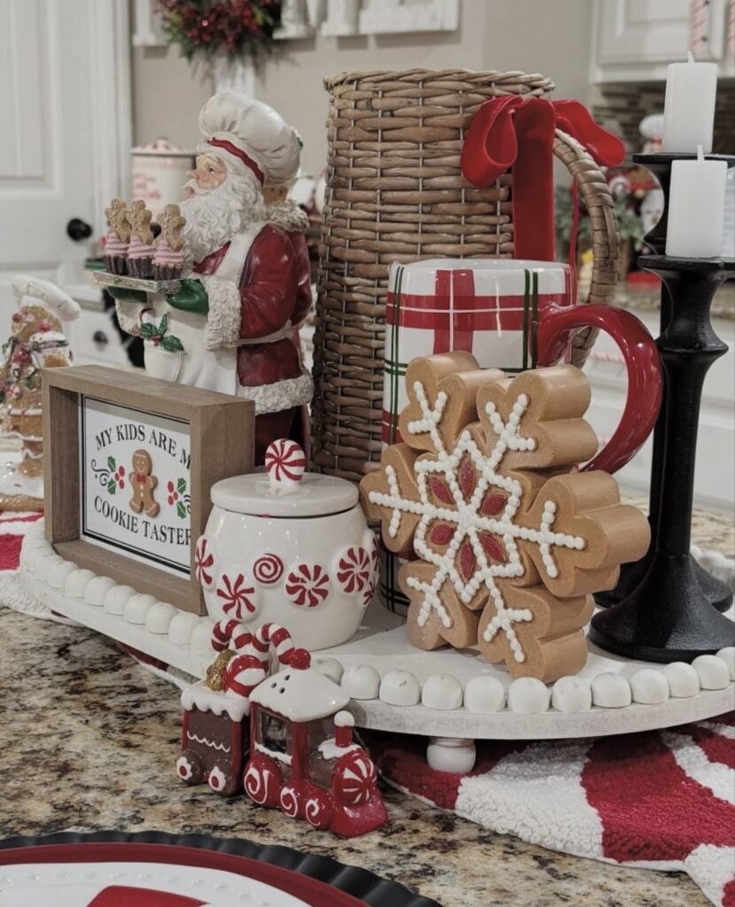 Gingerbread Santa kitchen centerpiece with cookie jars, snowflake cookie decor, plaid accents, and festive Christmas decorations, featured by slowestuff.com.