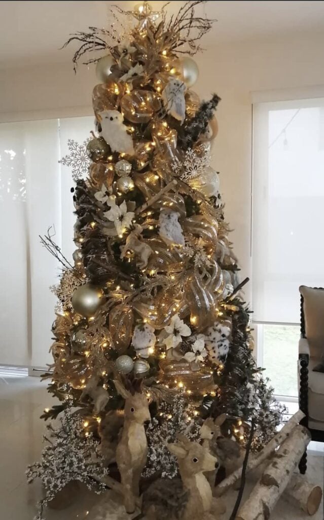Gold and white woodland Christmas tree with owls, birch logs, pinecones, and natural accents.