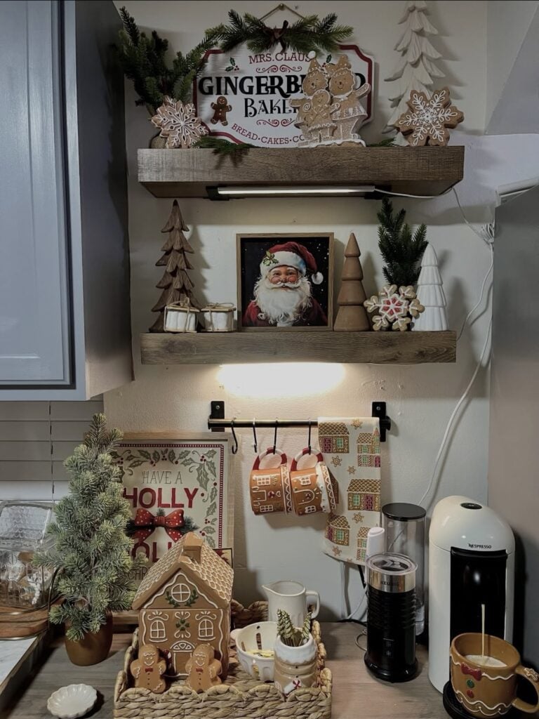 Gingerbread baking themed coffee station with open shelves, stacked cookbooks, gingerbread houses, mugs, and Christmas kitchen decor, featured by slowestuff.com.