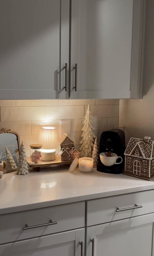 Neutral gingerbread Christmas coffee station with ceramic houses, bottle brush trees, and simple holiday decor, featured by slowestuff.com.