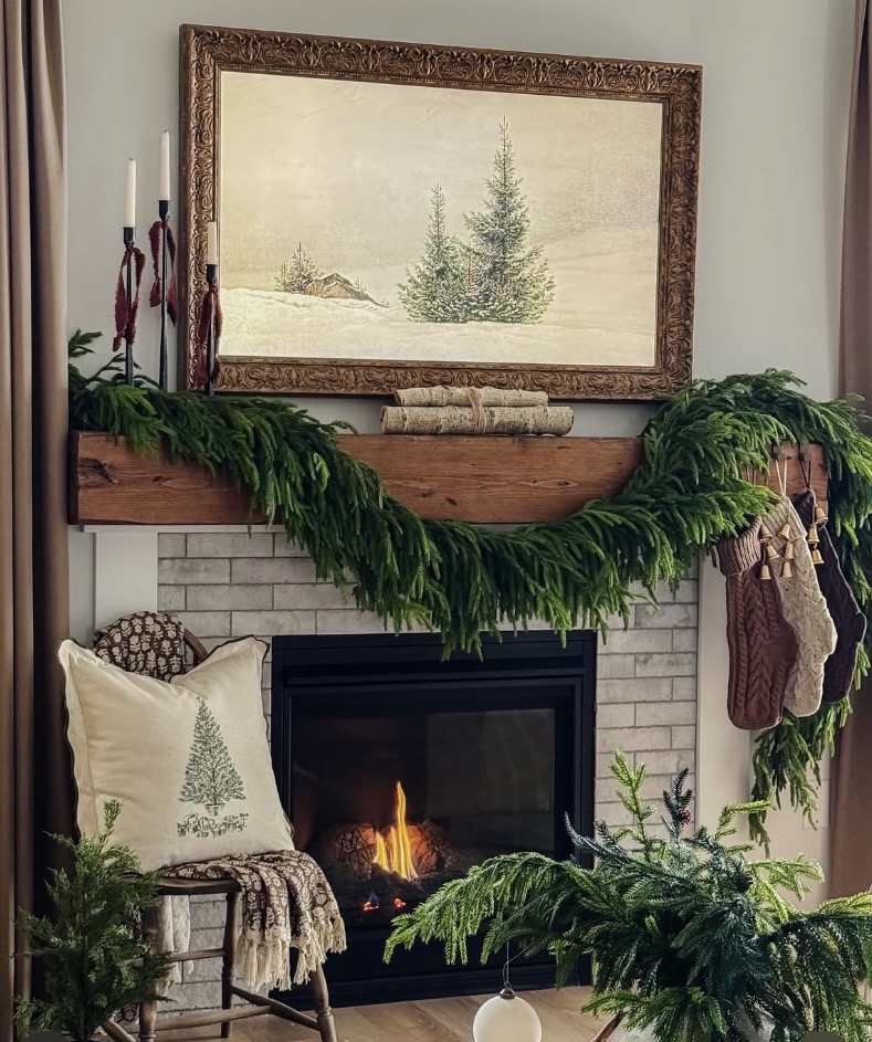 Simple neutral Christmas mantel decor with layered greenery and understated holiday accents for a warm seasonal look, featured by slowestuff.com.