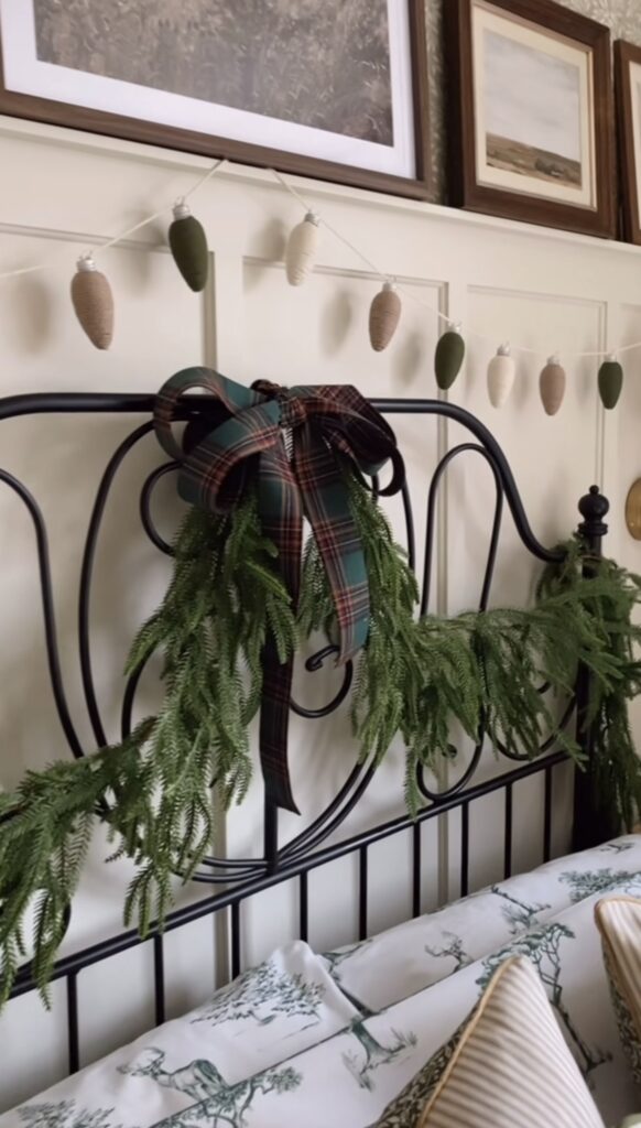 Christmas bedroom decorated with seasonal greenery and holiday decor across the bed headboard for a cozy Christmas look, featured by slowestuff.com.