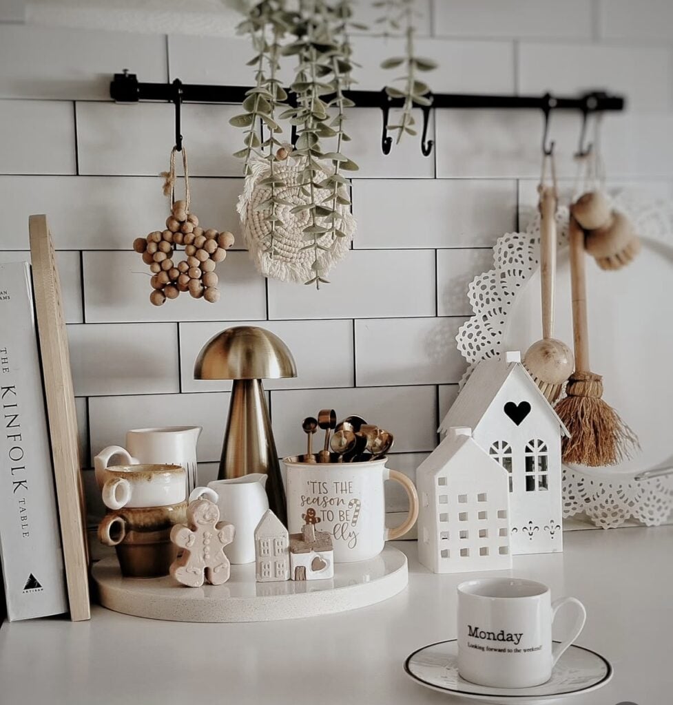 Neutral gingerbread kitchen tray with white ceramic houses, holiday mug, and simple Christmas decor, featured by slowestuff.com.