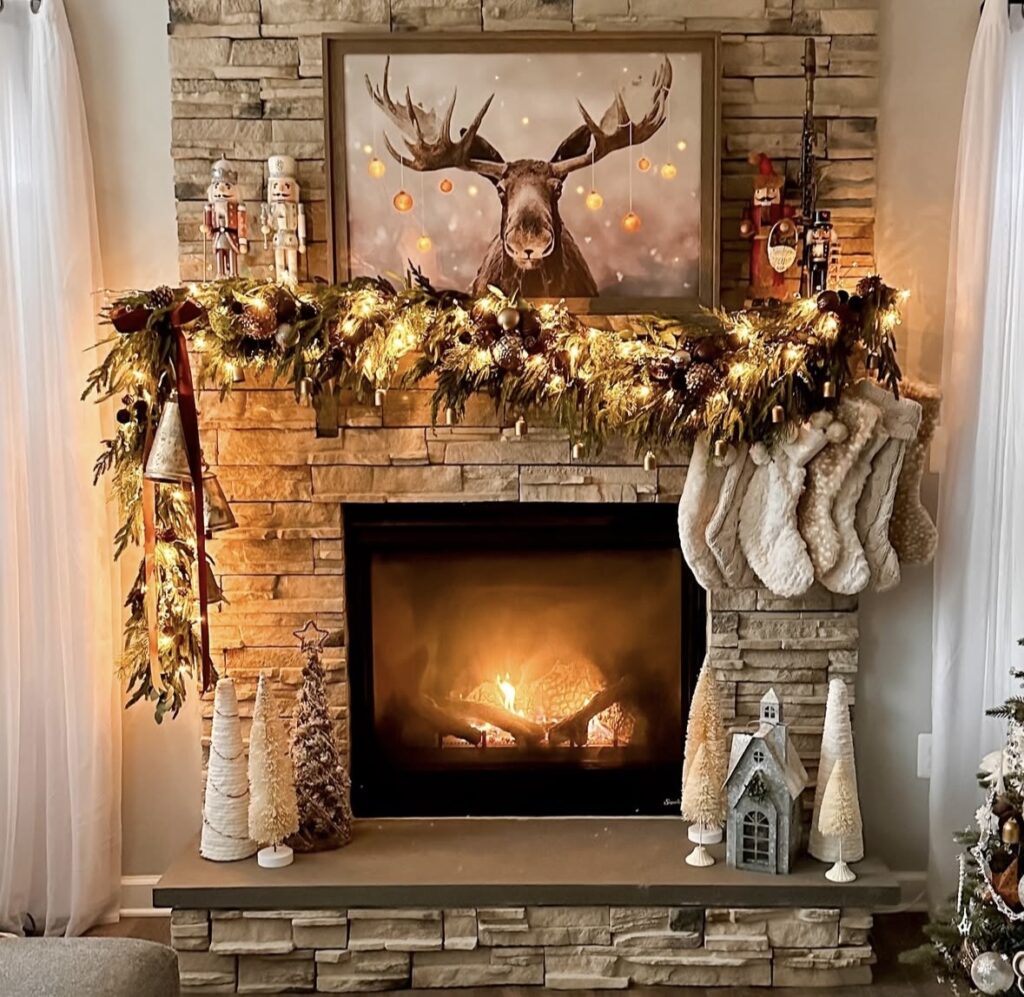 Brick fireplace mantel decorated with lush Christmas greenery and moose picture for a simple traditional holiday look, featured by slowestuff.com.