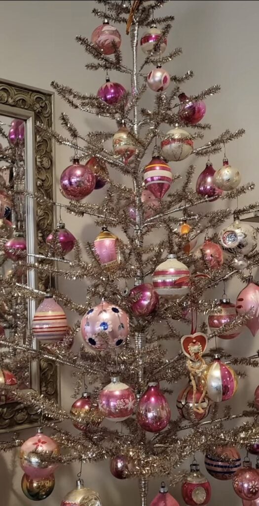 Non-traditional silver Christmas tree with unusual decorations and playful festive style
