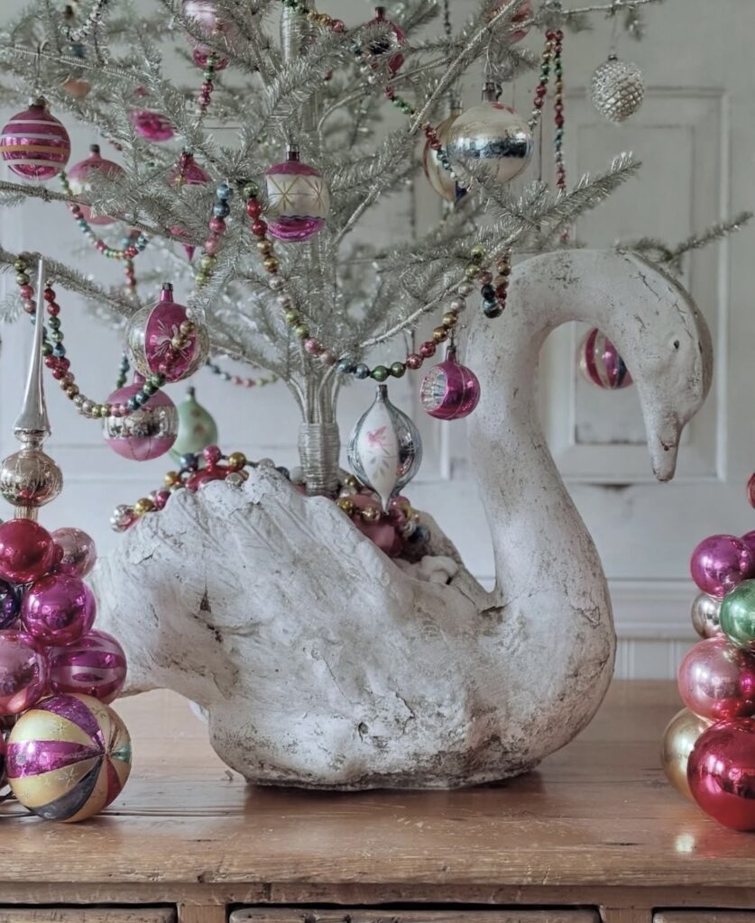 Unique Christmas tree swan base decorated in a non-traditional style with festive holiday accents