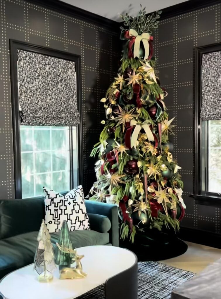 Traditional red, green, and gold Christmas tree with ribbon, ornaments, and festive holiday accents.