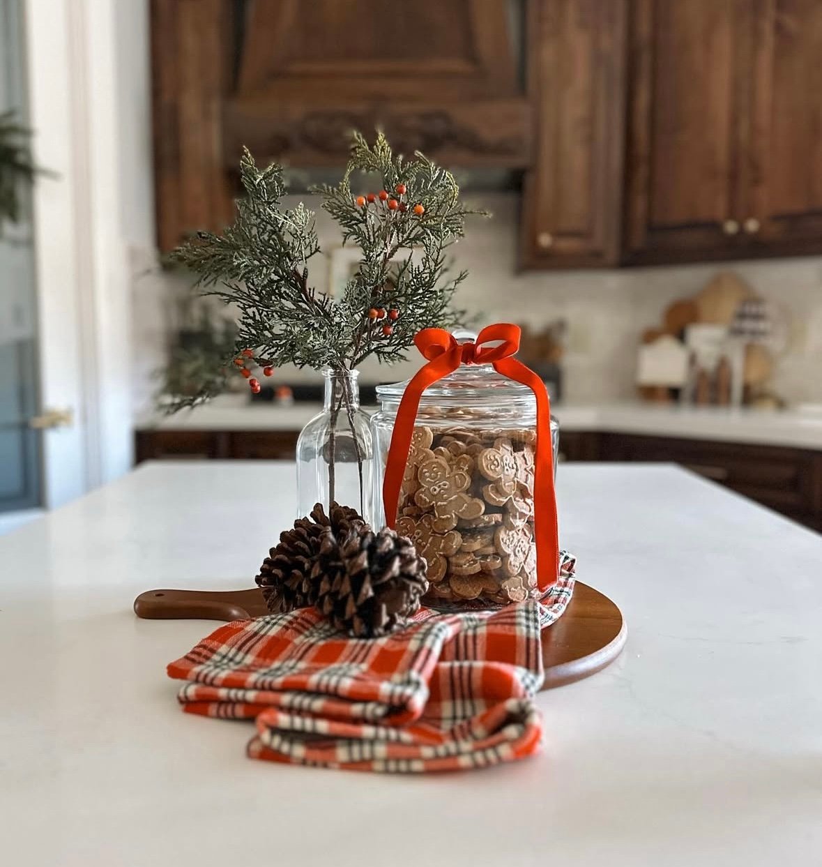 Simple gingerbread tray with stacked teatowels, gingerbread decor, and small trees for an easy Christmas display.