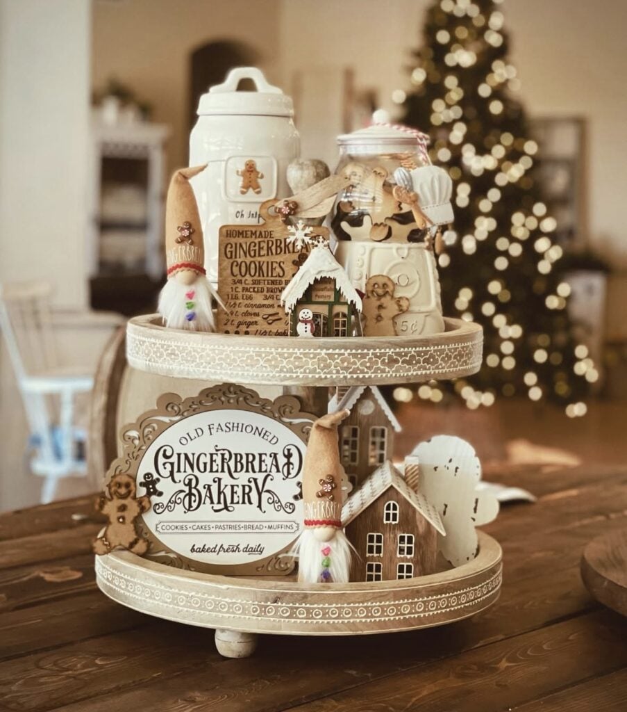 Neutral gingerbread bakery tiered tray with cream canisters, gingerbread signs, and small cookie houses.
