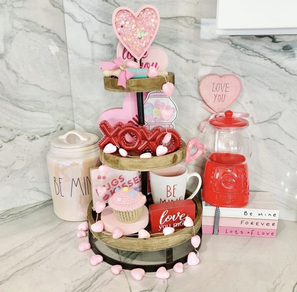 Valentine’s Day tiered tray decor with red and pink hearts, flowers, XOXO accents, and greenery.