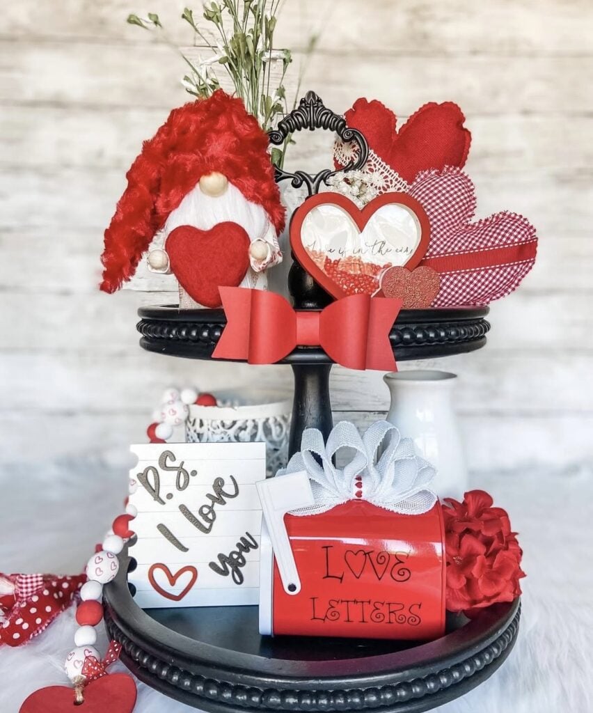 Valentine’s Day tiered tray styled with hearts and flowers, plus XOXO and greenery accents.