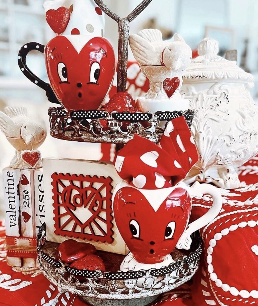 Bold red Valentine tiered tray with heart signs, roses, greenery, and candy touches.
