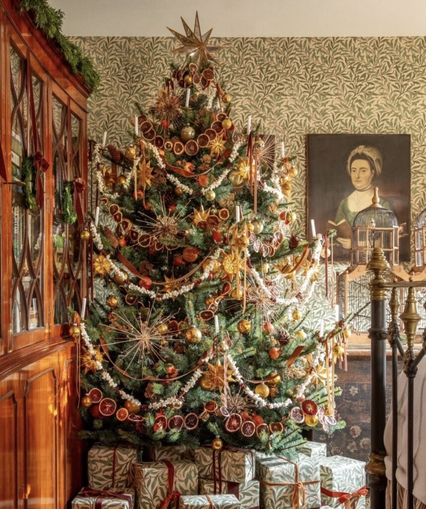 Winter Solstice tree decorated with evergreen branches, dried oranges, natural ornaments, candles, and woodland accents celebrating the return of the light.