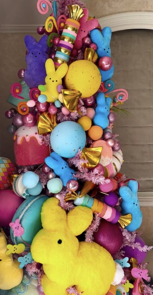 White Easter tree decorated with colorful Peeps bunny plush, pastel eggs, and a large patterned bow tree topper.